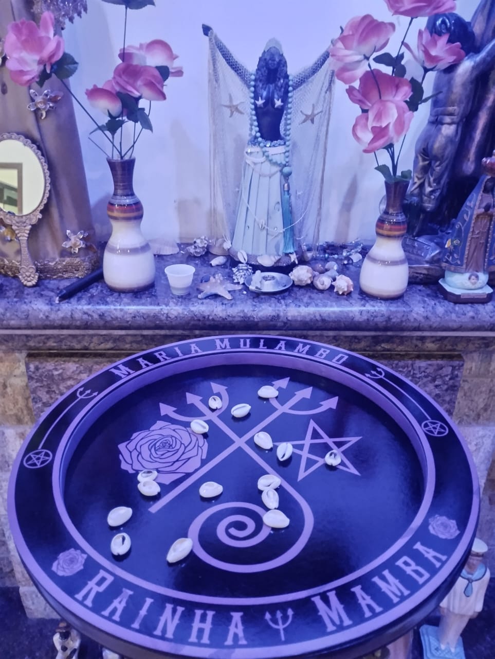 Altar sagrado da casa, com búzios e flores